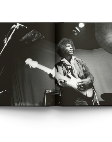 Book cover of Burning Desire: The Jimi Hendrix Experience Through the Lens of Ed Caraeff; featuring rock guitar legend Jimi Hendrix setting fire to his Fender Stratocaster. Published by ACC Art Books.