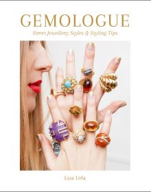 Model in red lipstick holding up ring covered fingers, on white cover of 'Gemologue Street Jewellery Styles & Styling Tips', by ACC Art Books.