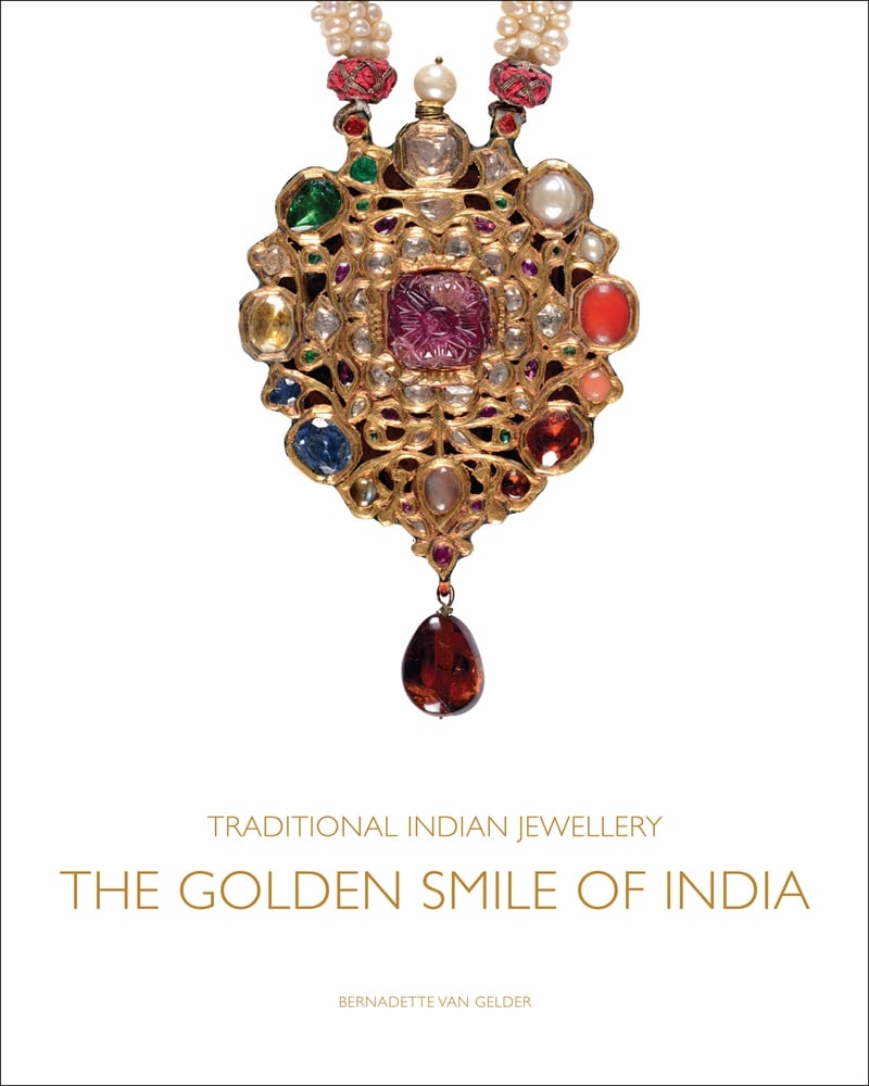 Pendant in the style of single flower on stem with a carved cabochon ruby in centre, on white cover of 'Traditional Indian Jewellery', by ACC Art Books.
