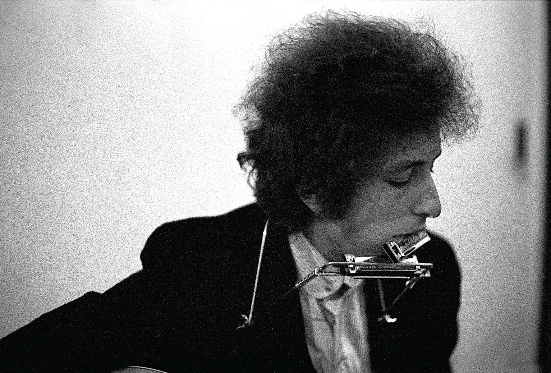 Bob Dylan in a white scarf looking at camera, on cover of 'Dylan By Schatzberg', by ACC Art Books.