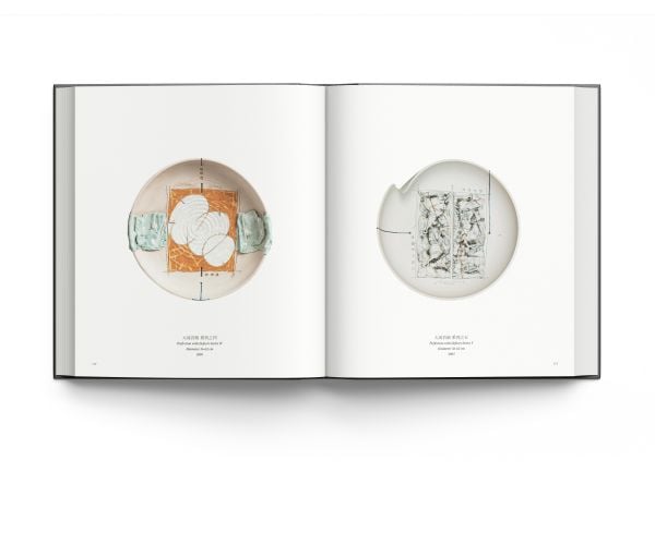 12 white shards of ceramic on black cover of 'Bai: The New Language of Porcelain in China', by ACC Art Books.