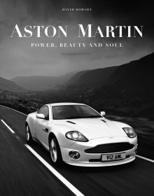 Book cover of Aston Martin: Power, Beauty and Soul, featuring a white Aston Martin V12 Vanquish on the road, with mountains behind. Published by Images Publishing.