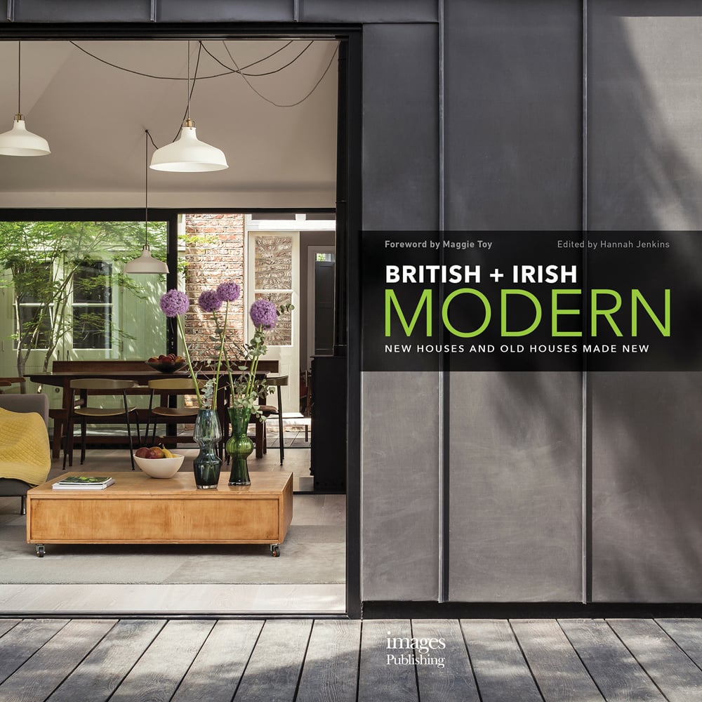 Large open door to interior, low table with purple alliums in vase, hanging light fittings, British + Irish Modern in white and green font