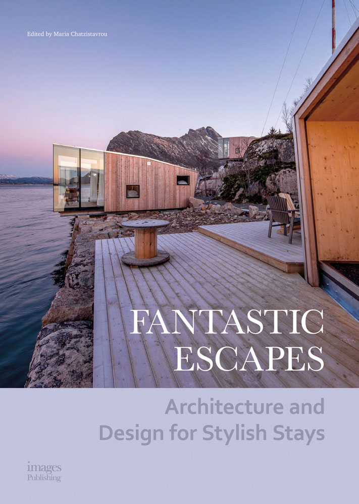 Modern glass and wood building by rocky cliff, wooden decking, next to sea, Fantastic Escapes in white font to lower right