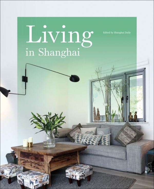 Book cover of Living in Shanghai, featuring an interior with a gray sofa, vase of lilies on a wood table, and three footstools. Published by Images Publishing.