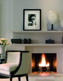 Book cover of On Interior Design featuring a beige interior space, with a sofa to center, an open fire and hanging light fittings from ceiling. Published by Images Publishing.