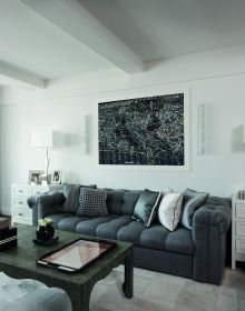 Book cover of On Interior Design featuring a beige interior space, with a sofa to center, an open fire and hanging light fittings from ceiling. Published by Images Publishing.
