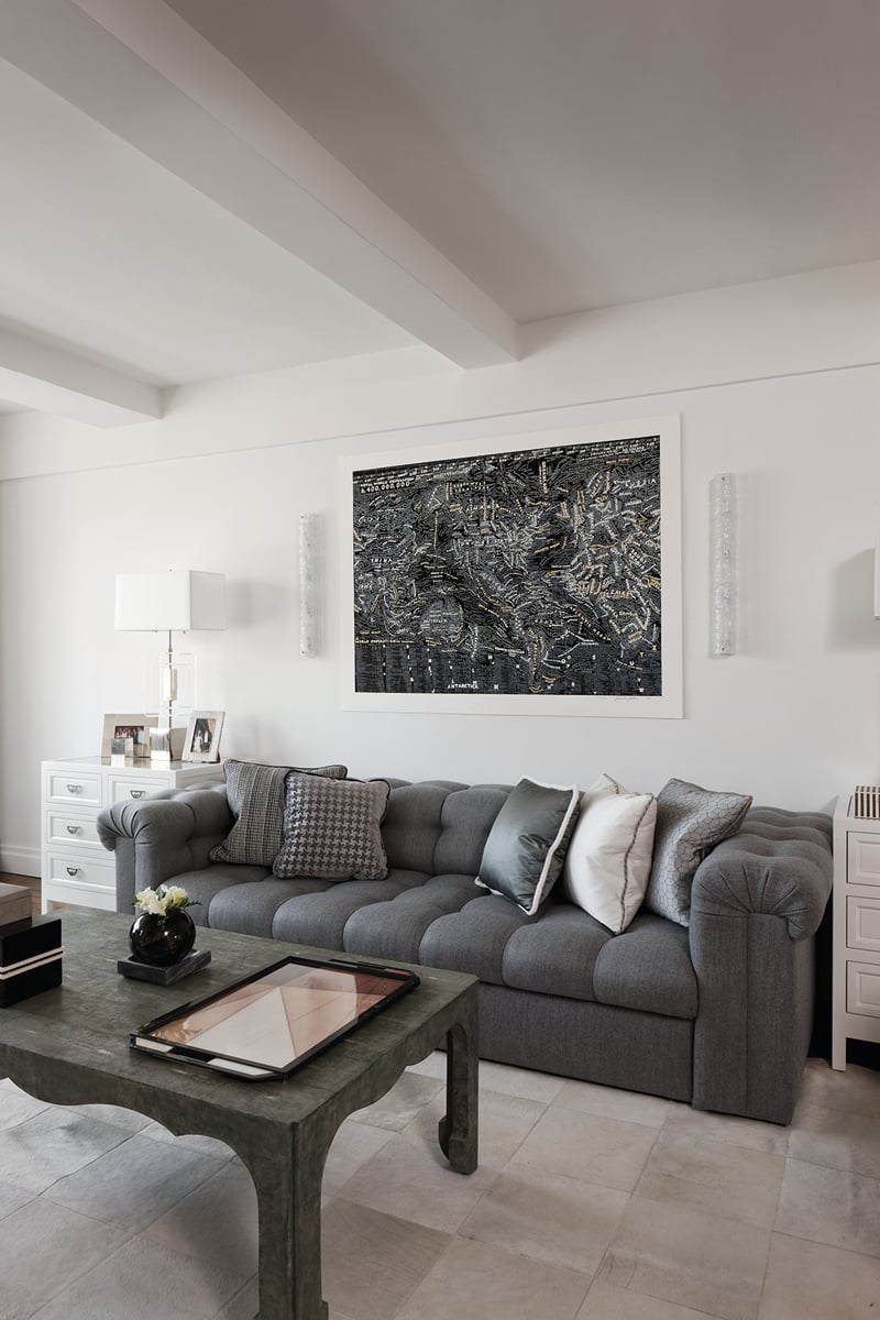 Beige interior space, central sofa, lit open fire, hanging light fittings, PENNY DRUE BAIRD On Interior Design in brown font above