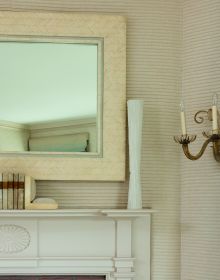 Book cover of On Interior Design featuring a beige interior space, with a sofa to center, an open fire and hanging light fittings from ceiling. Published by Images Publishing.