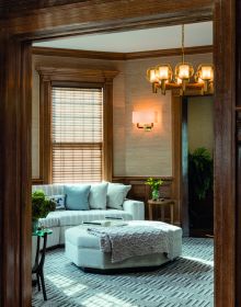 Book cover of On Interior Design featuring a beige interior space, with a sofa to center, an open fire and hanging light fittings from ceiling. Published by Images Publishing.