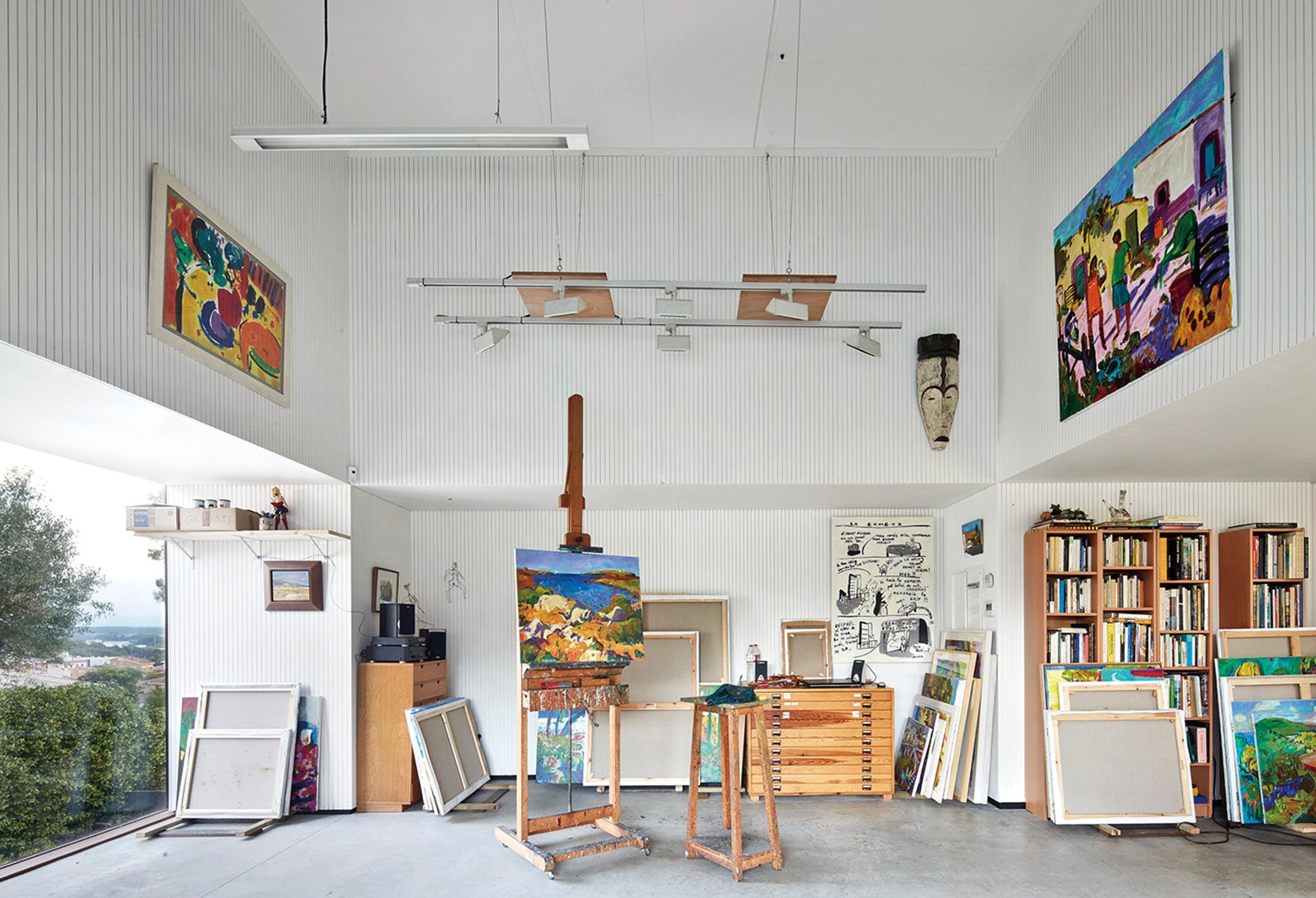 Artist sitting in wood studio, tree hammock in foreground, on green cover, Creative Spaces for Creative Ideas in white font above.