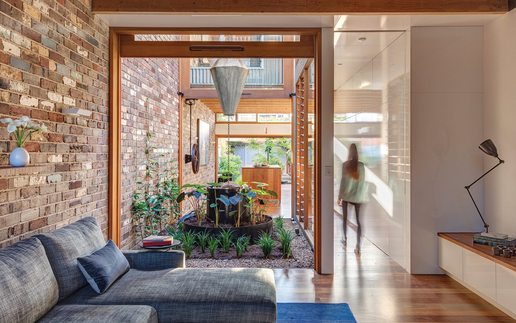 Modern exterior garden space with dining set, grey decking, Urban Oasis Tranquil Outdoor Spaces at Home in white font on grey banner to centre.