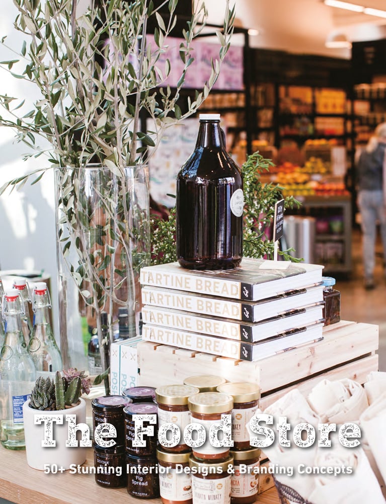 Table full of jars of artisan food products, in retail food interior, The Food Store in white distressed font below.