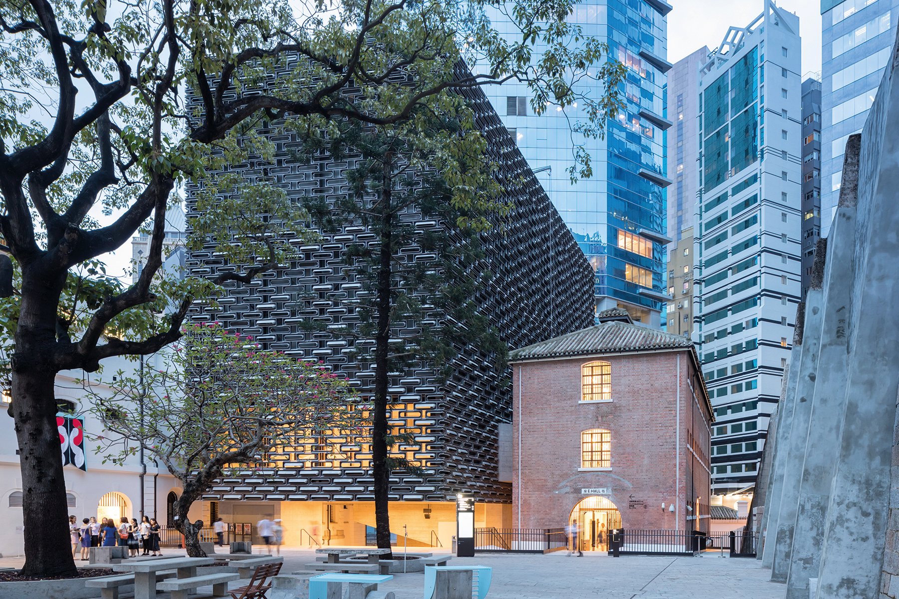 Building façade with dark grey modern exterior cover, ARCHITECTURE CHINA RE/DEFINE TRADITION in beige and white font above and below.