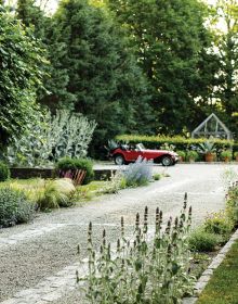 Landscaped garden with topiary hedge and sculpture of face, INTERSECTION OF NATURE AND ART, in small white font above centre cover.