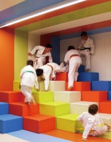 Book cover of Contemporary Creative Spaces for Children, featuring two boys playing on suspended multicoloured webbing. Published by Images Publishing.