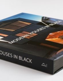 Book cover of Susan Redman's Modern Homes in Black, with a black wooden lake house in Berlin, surrounded by a garden. Published by Images Publishing.