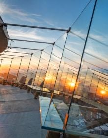 Saucer-shaped top of Seattle Space needle, yellow sunset behind, on cover of 'New Heights, Transforming Seattle's Iconic Space Needle', by Images Publishing.