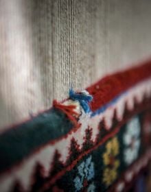 Montage of colourful pattered rugs, on white cover of 'The Handmade Carpet, A Comprehensive Guide to Contemporary Rugs', by Hali Publications.