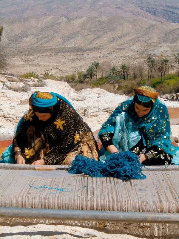 Montage of colourful pattered rugs, on white cover of 'The Handmade Carpet, A Comprehensive Guide to Contemporary Rugs', by Hali Publications.