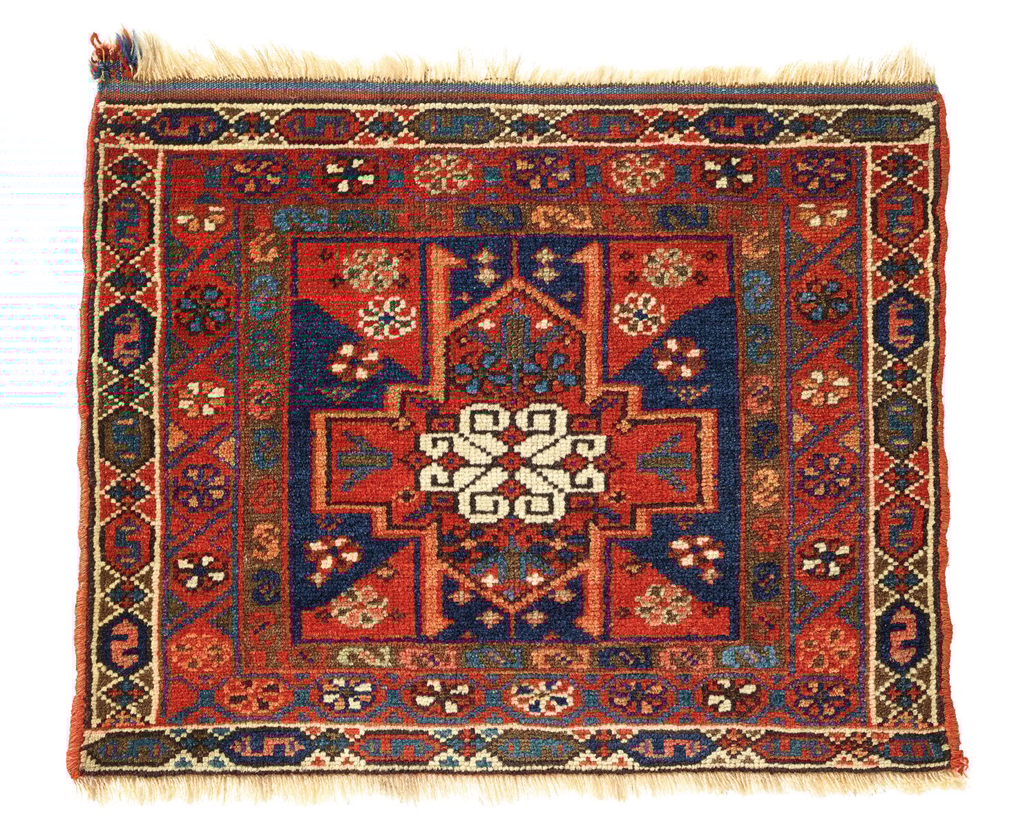 Orange rug with four animals and diamond patterns on cover of 'Nomadic Visions', by Hali Publications.