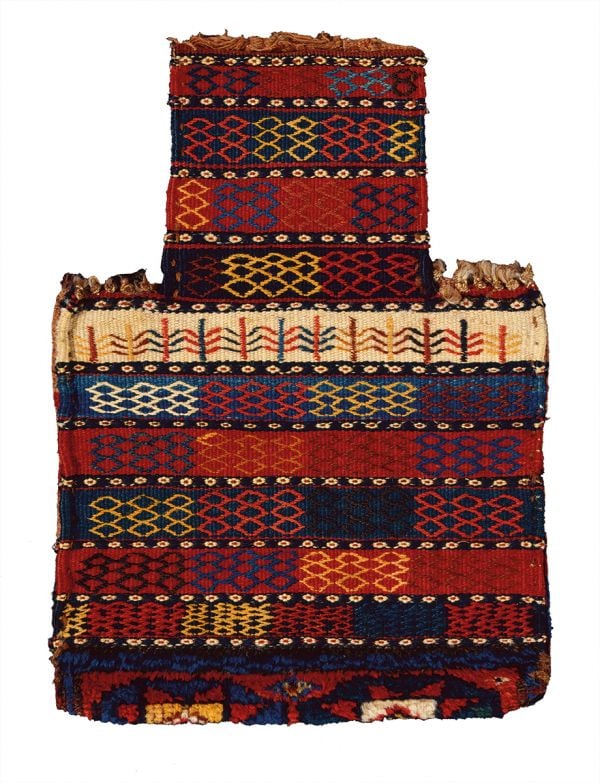 Orange rug with four animals and diamond patterns on cover of 'Nomadic Visions', by Hali Publications.