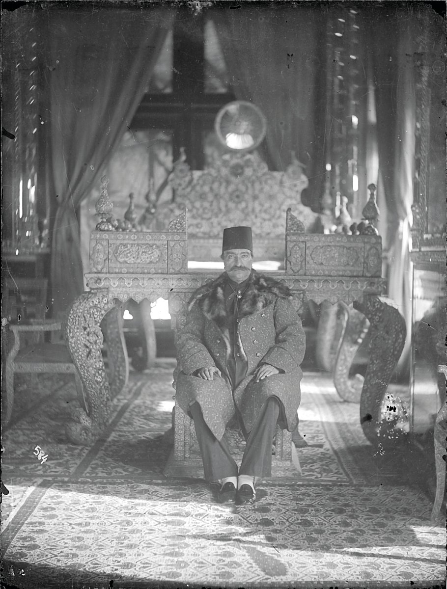 Bold Persian carpet design, with red and orange diamond shapes, black filter over top half, The Persian Carpet in bronze font to upper right.