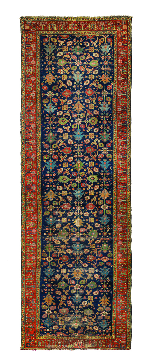 Bold Persian carpet design, with red and orange diamond shapes, black filter over top half, The Persian Carpet in bronze font to upper right.