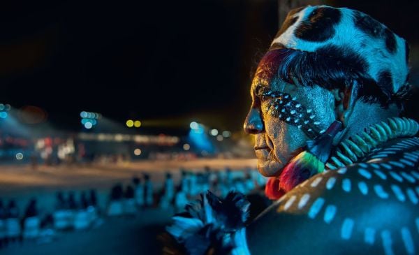 Book cover of Sue and Patrick Cunningham's Spirit of the Amazon: The Indigenous Tribes of the Xingu, featuring the eye of a tribesman with black tribal marks below. Published by Papadakis.