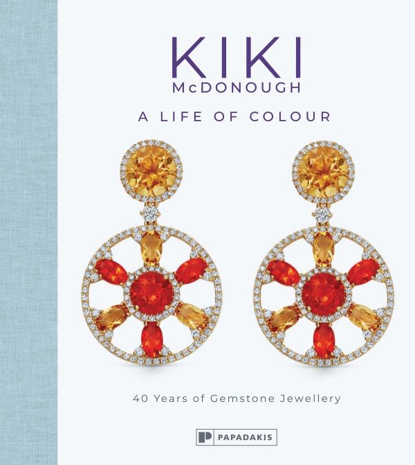 Book cover of Kiki McDonough: A Life of Colour: 40 Years of Gemstone Jewellery, featuring a pair of jewel encrusted earrings. Published by Papadakis.