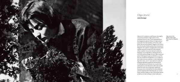 Photograph of industrial rock sculpture with rusted metal poles, in white exhibition space, 'OLGA JEVRI?', in orange font to upper left, by Ridinghouse.