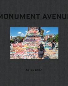 Grey statue covered in graffiti, with a placard, on black cover of 'Monument Avenue', by Circa Press.