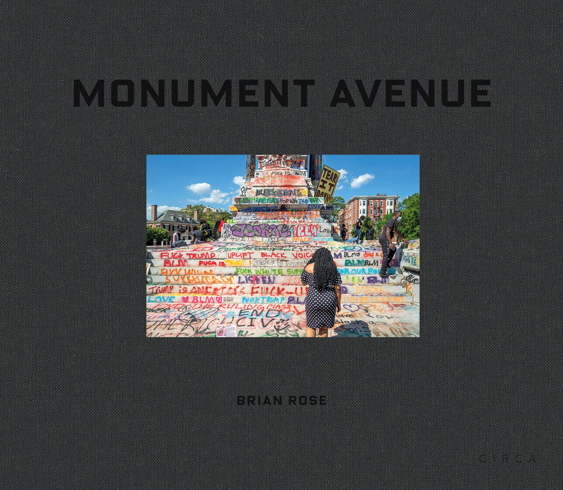 Grey statue covered in graffiti, with a placard, on black cover of 'Monument Avenue', by Circa Press.