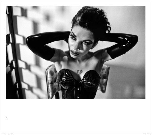 Woman in red suit sitting on Mae West lips sofa, with her red stilettos across a nude woman laying on floor, on cover of 'Alejandra Guerrero - Wicked Women', by Circa Press.