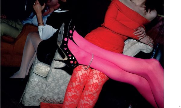 Female lounging on red chaise longue with red stiletto heels, on black cover of 'Frank Rispoli - High Heels', by Circa Press.