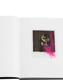 Blonde model in long black PVC gloves posing on bed, on black wood-effect cover of 'Boudoir', by Circa Press.