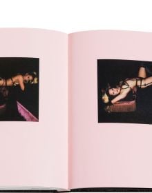 Blonde model in long black PVC gloves posing on bed, on black wood-effect cover of 'Boudoir', by Circa Press.