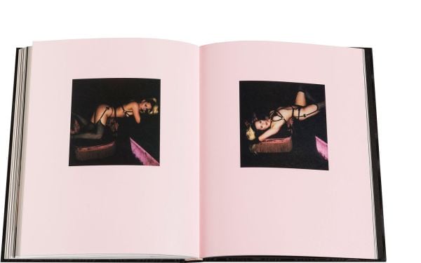 Blonde model in long black PVC gloves posing on bed, on black wood-effect cover of 'Boudoir', by Circa Press.