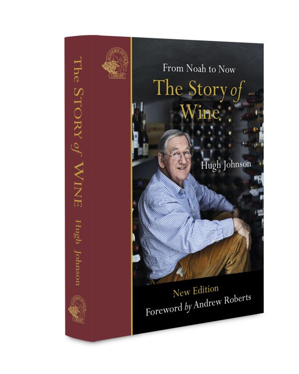 Book cover of The Story of Wine, From Noah to Now The Story of Wine, with Hugh Johnson sitting inside wine storage room. Published by Academie du Vin Library..