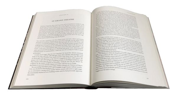 Book cover of The Story of Wine, From Noah to Now The Story of Wine, with Hugh Johnson sitting inside wine storage room. Published by Academie du Vin Library..