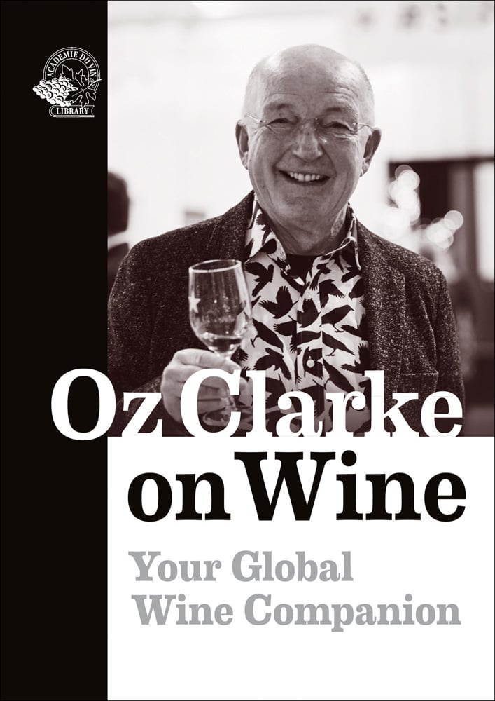 Smiling Oz Clarke in bird print shirt, holding glass of wine in hand, on cover of 'Oz Clarke on Wine, Your Global Wine Companion' by Academie du Vin Library.