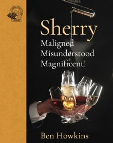 Bartender's hand elegantly grasps 8 sherry glasses and pours liquid into them from a height with Sherry in pale orange and a gold-yellow border to left portion