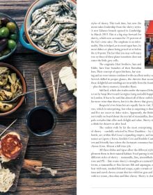 Book cover of Sherry, Maligned*Misunderstood*Magnificent!, featuring a bartender's hand holding 8 sherry glasses while pouring sherry. Published by Academie du Vin Library..