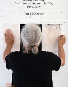 Book cover of Talking Painting: Writings on Art and Artists, 1977–2025: Ian McKeever; featuring artist facing away from the viewer, hanging a piece of work on wall. Published by Royal Academy of Arts.