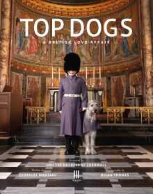 Book cover of Georgina Montagu's Top Dogs: A British Love Affair, with a castle guard in purple coat standing with an Irish wolfhound. Published by Triglyph Books.