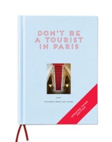 Aerial view of red stairs leading down to black and white checked tiled floor, on pale blue cover of 'Don't be a Tourist in Paris', by 13 Things Ltd.