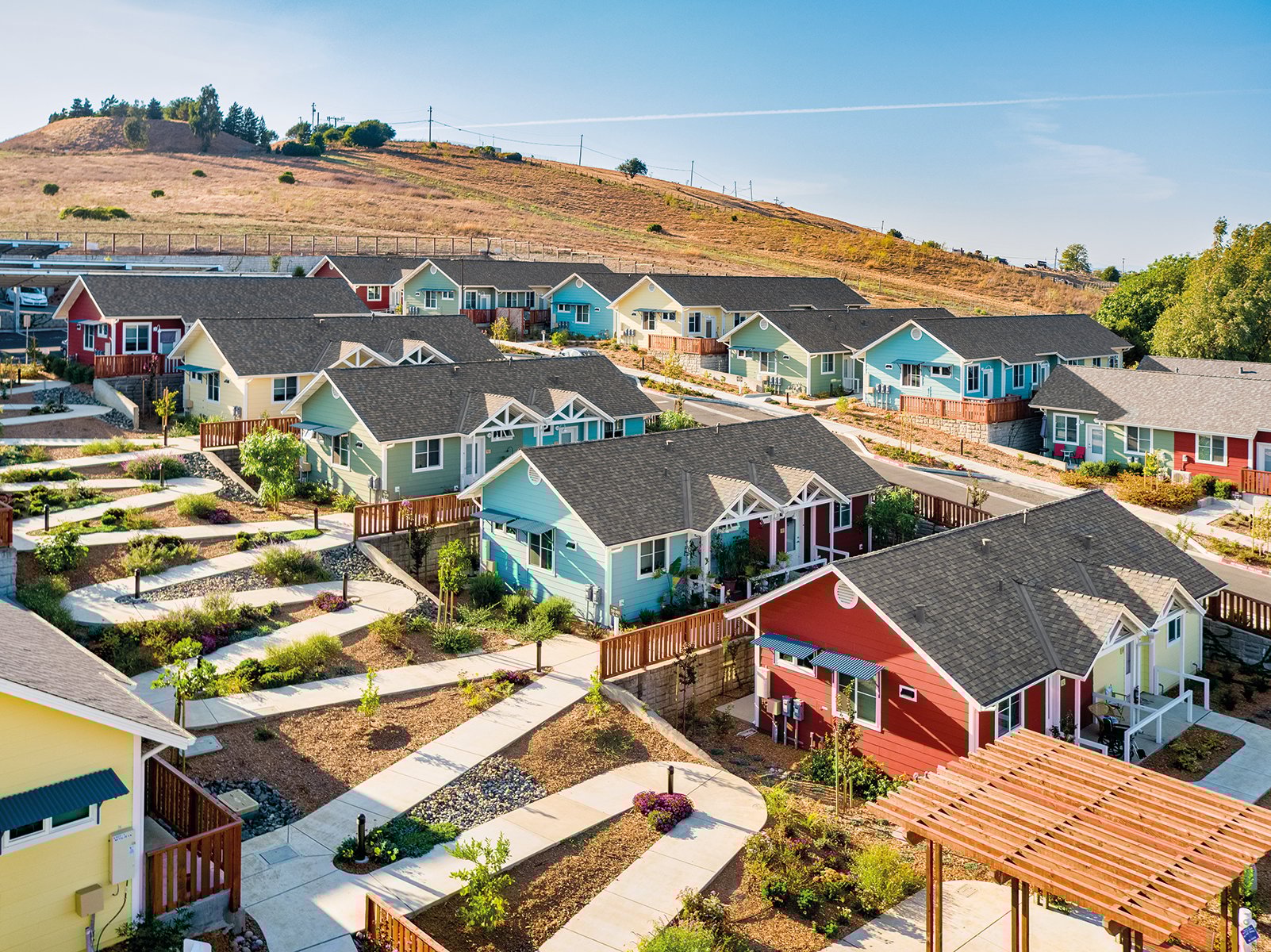 Urban housing estate surrounded by hilly landscape, A solution to homelessness in your town Valley View Senior Housing Napa County California in blue font above.