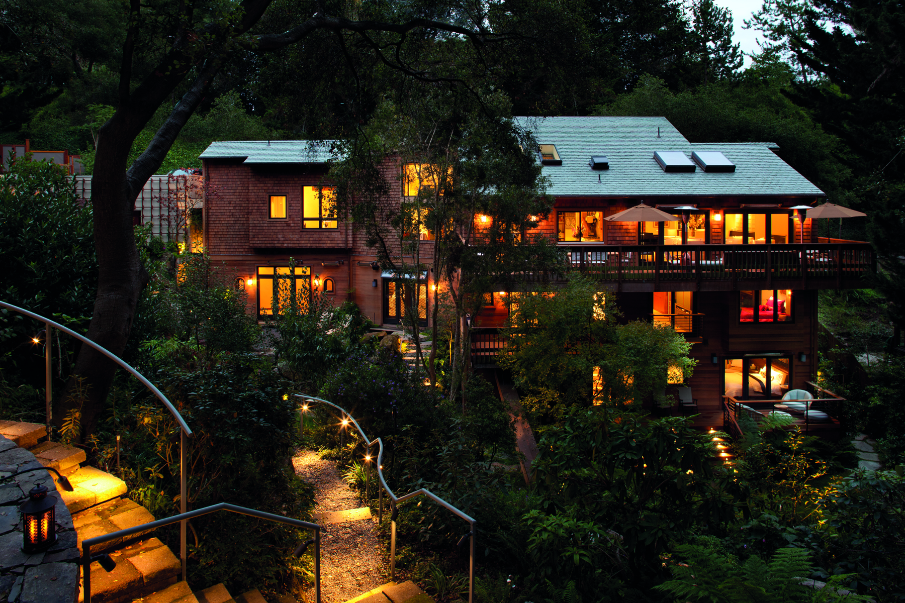 Single storey wood house with low steps leading to swimming pool, Pacific Modern in white font above