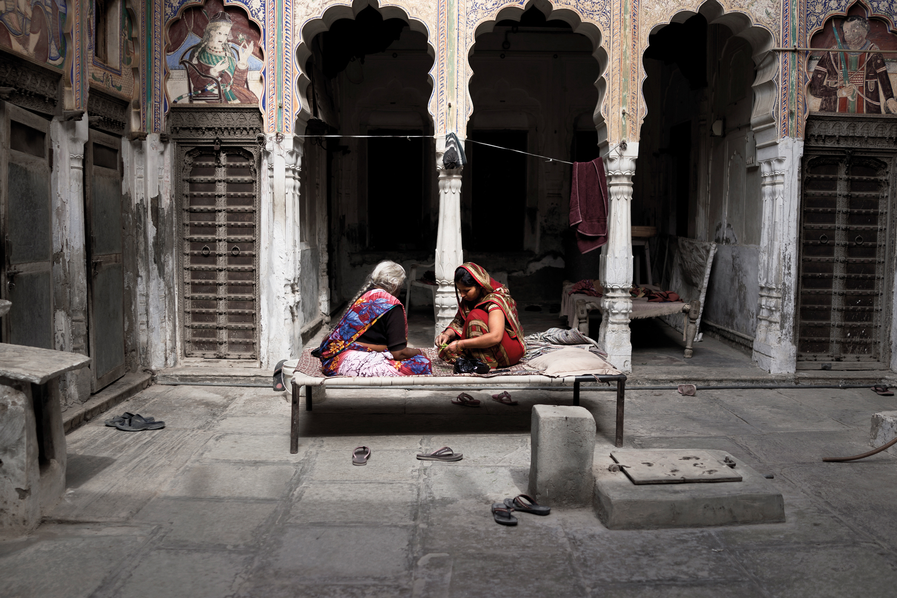 Fresco painting of Indian female, holding pot on head, brown handprint with Fantastic State of Ruin in black font above