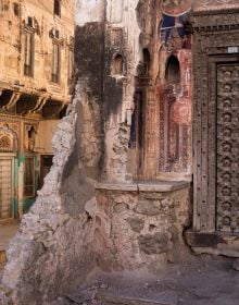 Fresco painting of Indian female, holding pot on head, brown handprint with Fantastic State of Ruin in black font above